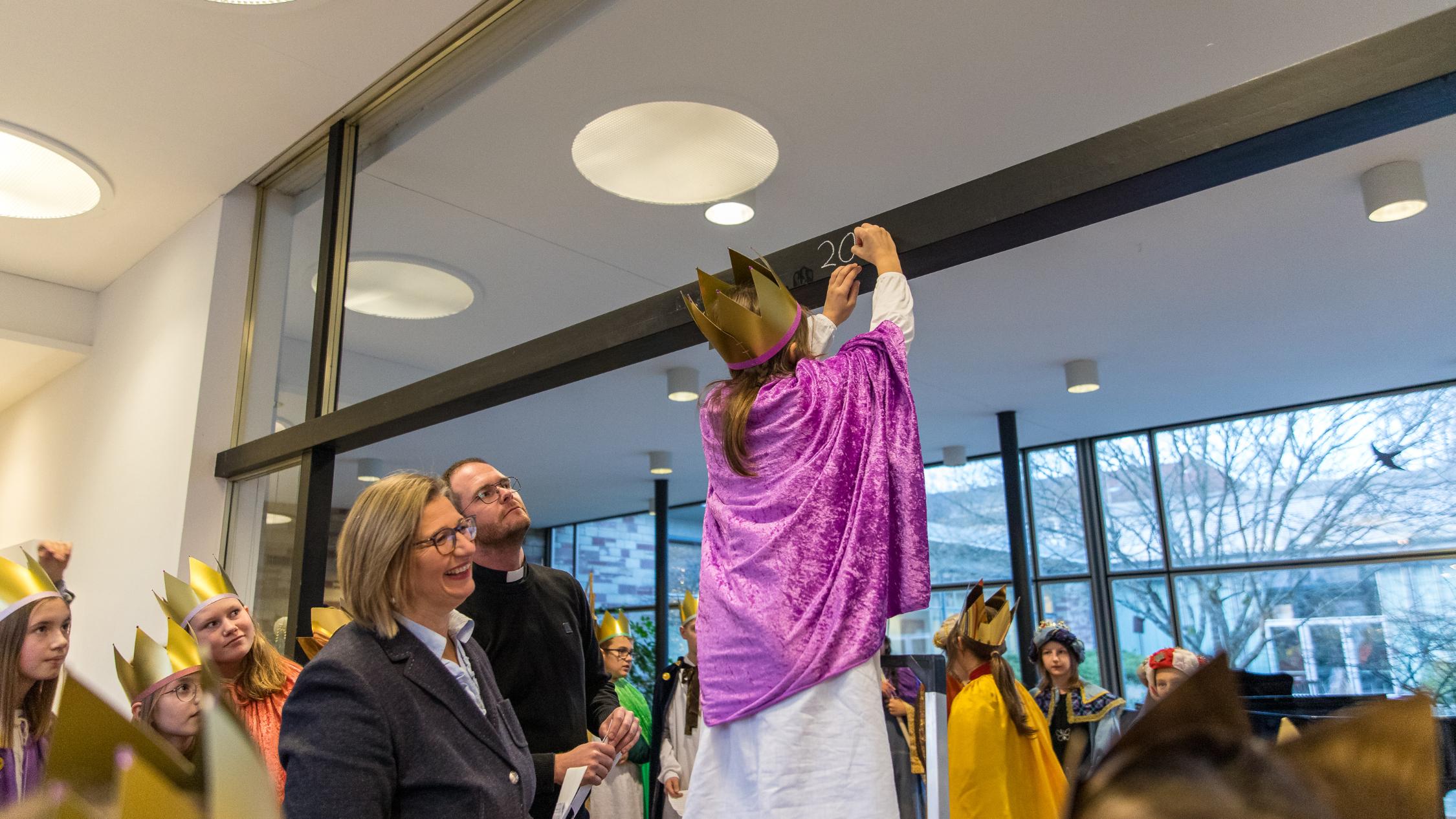 Louisa (9) aus Nunkirchen schreibt den Segen an.